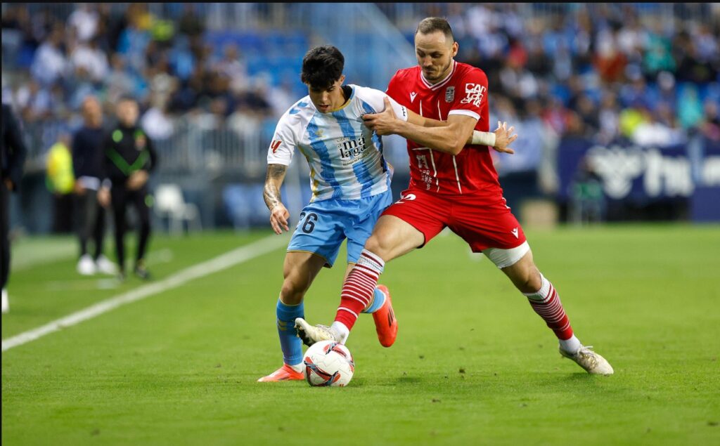 Jugadores del Málaga CF y FC Cartagena disputan el balón en La Rosaleda.